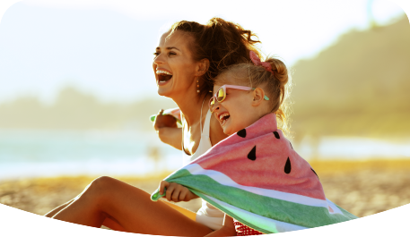 Mother and daughter laughing and spending time on the beach