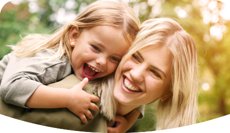 Young blonde smiling woman giving her daughter a piggy ride