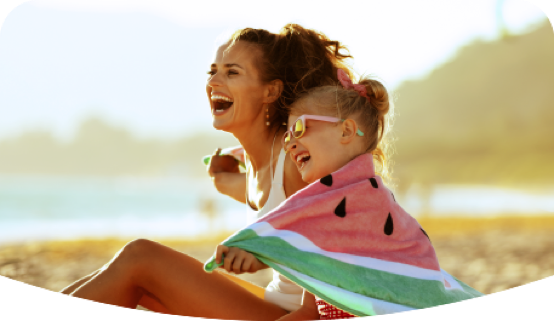 Madre e hija riendo en la playa